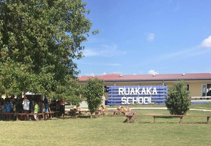 A school sign in front of a brick building